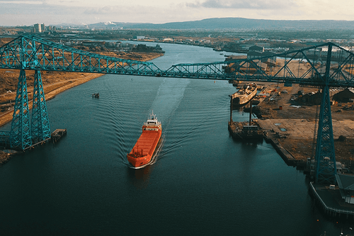 A large shipping freighter sailing down the Mercy river. 