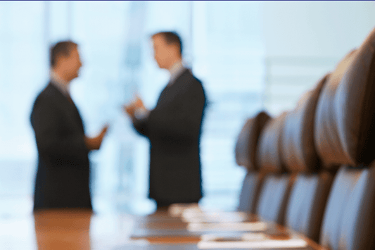 Two men discussing business in a conference room. 