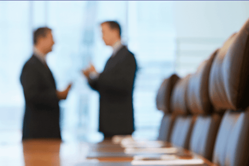 Two men discussing business in a conference room. 