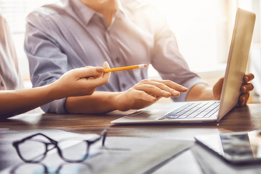 Coworkers working out logistics on computer