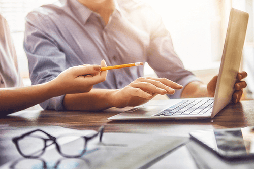 Coworkers working out logistics on computer