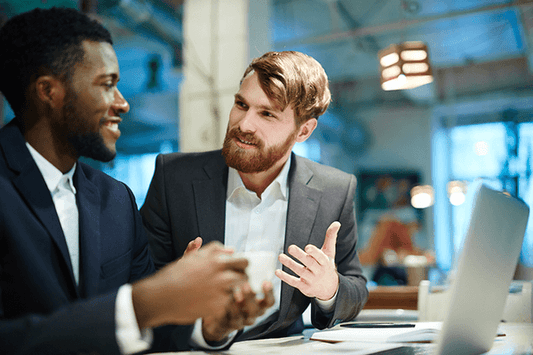 Colleagues conversing at a desk