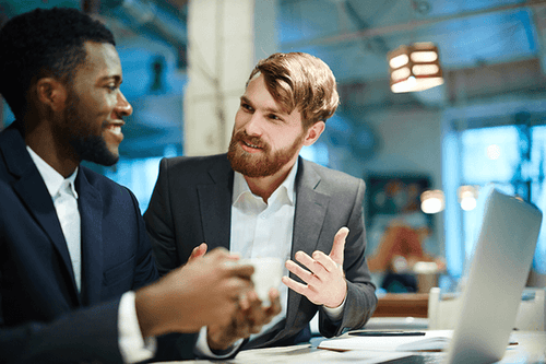 Colleagues conversing at a desk